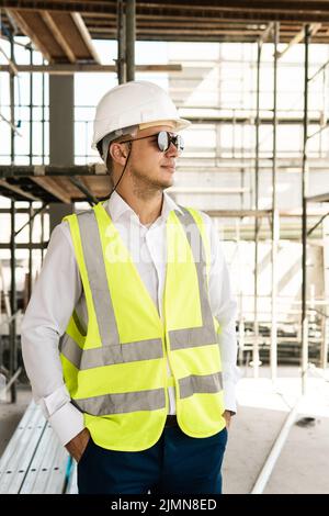 Architetto che indossa il giubbotto di sicurezza in cantiere Foto Stock