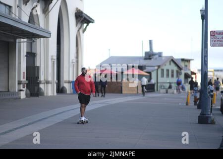 Un giovane barbuto che cavalca uno skateboard su una strada a San Francisco Foto Stock