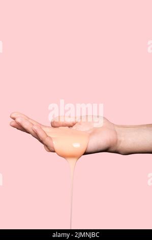 Persona con sapone liquido arancione Foto Stock