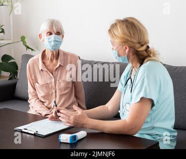 Infermiera donna anziana che parla casa di cura Foto Stock