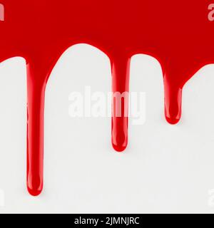 Vernice rossa gocciolante sfondo bianco Foto Stock