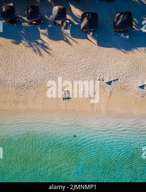 Vista aerea del drone di una spiaggia tropicale, uomini e donne che camminano su una spiaggia tropicale a Mauritius Foto Stock