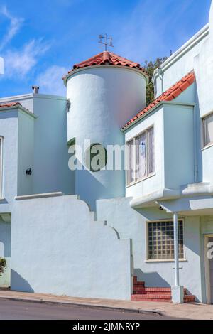 Facciata di una casa di stile mediterraneo grigio con tetti di piastrelle di cemento. Esterno di una casa con mattoni sulle scale nella parte anteriore vicino alla colonna e wi Foto Stock