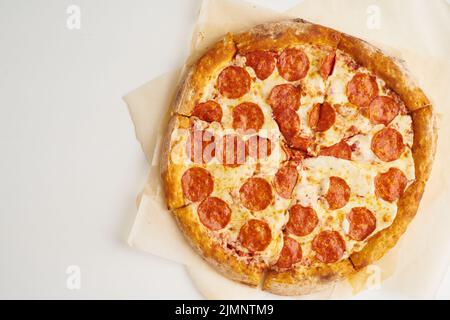 Pizza italiana Pepperoni su carta da forno vista dall'alto Foto Stock