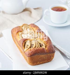 Pane alla banana, torta con banana, vista laterale. La colazione del mattino con tè su sfondo grigio chiaro Foto Stock