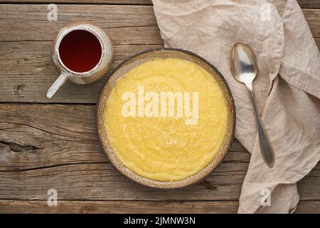 Polenta di porridge con tè da tazza, sfondo di legno scuro, vista dall'alto Foto Stock