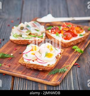 Smorrebrod - panini tradizionali danesi. Pane di segale nero con pesce Foto Stock