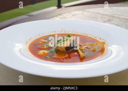 Cucina tradizionale francese. Il famoso piatto dei pescatori di Marsiglia Bouillabaisse zuppa con gamberi, cozze e pesce in un piatto bianco. Foto Stock