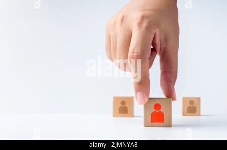 Mano di primo piano scelta di uno di un rosso umano o persone icona su blocco di legno cubo da un altro isolato su sfondo bianco con spazio copia. Concetto o Foto Stock