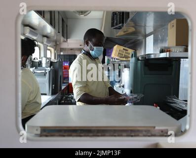 (220807) -- NAIROBI, 7 agosto 2022 (Xinhua) -- Mark lavora in cucina di un treno passeggeri ferroviario Mombasa-Nairobi, 29 luglio 2022. Lanciato il 31 maggio 2017, il 480 km Mombasa-Nairobi Standard Gauge Railway (SGR), finanziato principalmente dalla Cina e costruito dalla China Road and Bridge Corporation (CRBC), ha favorito la creazione di posti di lavoro per la popolazione locale. Afristar, la società che opera la SGR, ha impiegato keniani in 123 professioni ferroviarie che rientrano sotto 5 dipartimenti ferroviari, compresi trasporto ferroviario, locomotiva, binario, segnale, e materiale rotabile. A partire da luglio 31, ci sono attualmente 1.359 Foto Stock