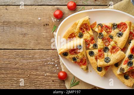 Focaccia, pizza, fette di pane italiano piatto con pomodori, olive e rosmarino Foto Stock