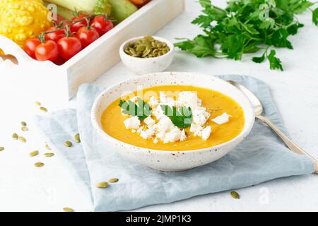 Zuppa di crema di zucca con formaggio feta, cibo casereccio autunnale, fondo bianco, primo piano Foto Stock