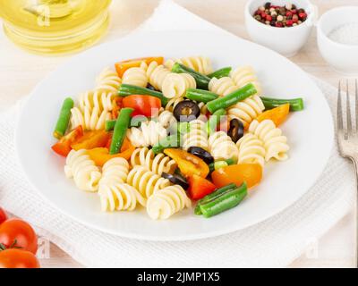 Insalata italiana con pomodori fusilli in pasta, olive, fagioli verdi, vista laterale, primo piano Foto Stock