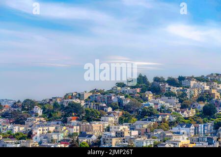 File di edifici residenziali con alberi all'aperto a San Francisco, California. Vista ad angolo alto degli edifici di appartamenti nei sobborghi su un pendio e a. Foto Stock