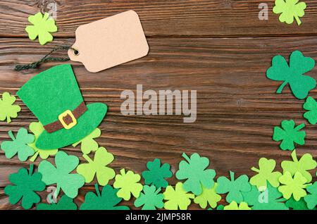 Happy Saint Patrick's mockup del feltro a mano hat e shamrock clover foglie su sfondo di legno. Foto Stock