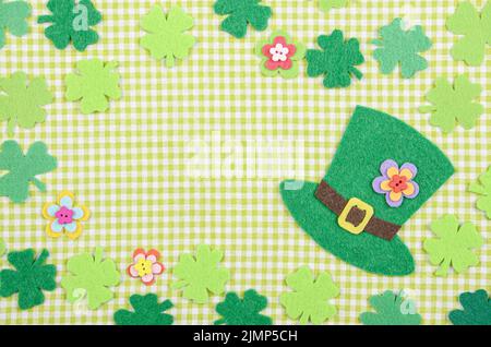 Piatto felice laici San Patrizio background mockup del feltro a mano shamrock trifoglio fiori foglie e hat sul tovagliolo verde Foto Stock