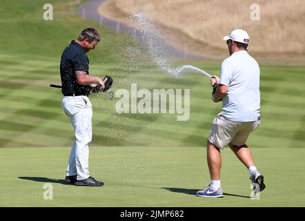 Il Callum Shinkwin dell'Inghilterra viene spruzzato con Champagne sul verde 18th dopo aver vinto il Cazoo Welsh Open durante il giorno quattro del Cazoo Wales Open al Celtic Manor Resort di Newport, Galles. Data foto: Domenica 7 agosto 2022. Foto Stock