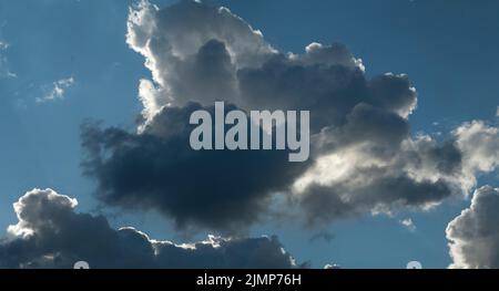 Nuvole di pioggia pesante con cielo blu dietro Foto Stock