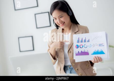 Giovane donna asiatica d'affari che usa il computer portatile per la videoconferenza online, donna d'affari che lavora con la videochiamata per la riunione e mostrare il repo grafico Foto Stock