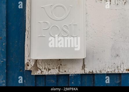 Cassetta postale bianca sulla parete di legno della casa di colore blu Foto Stock