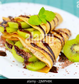 Kiwi crepes con salsa di cioccolato Foto Stock