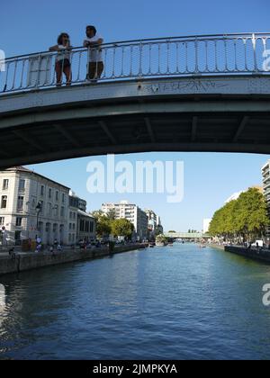 Un paio di escursionisti in estate su un ponte del Canal de l'Ourcq, a Parigi Foto Stock