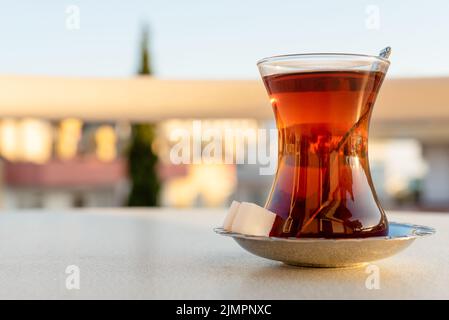 Tradizionale tè turco in un bicchiere di vetro con un piattino Foto Stock