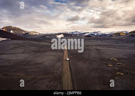 Vista aerea del deserto vulcanico nero sulla natura selvaggia con un'auto 4x4 parcheggiata a Landmannalaugar nelle Highlands islandesi Foto Stock