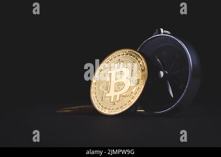 Bussola e bitcoin. Viaggi e criptovalute. Acquisto di biglietti con bitcoins. Valuta alternativa e viaggi. Moneta e bussola sulla mappa. Foto Stock