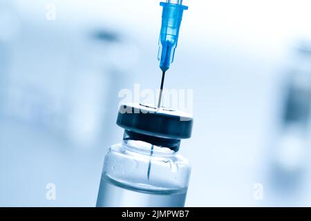 Siringa medica con un ago e un bollte con il vaccino. Foto Stock