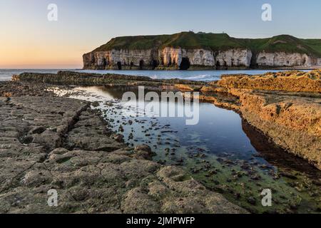 Scogliere di gesso e grotte marine a Thornwick Bay sulla costa orientale dello Yorkshire, Inghilterra, Regno Unito. Preso all'alba. Foto Stock