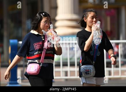 Fuyang, Cina. 07th ago 2022. Le donne camminano lungo la strada mentre bevono bevande fredde durante il tempo caldo. Secondo le previsioni dell'Osservatorio Meteorologico Centrale della Cina, nei prossimi 10 giorni, le alte temperature continueranno in alcune parti della Cina, con la temperatura massima che raggiunge i 37-39 ° C e la temperatura locale di 40 ° C o superiore. Credit: SOPA Images Limited/Alamy Live News Foto Stock