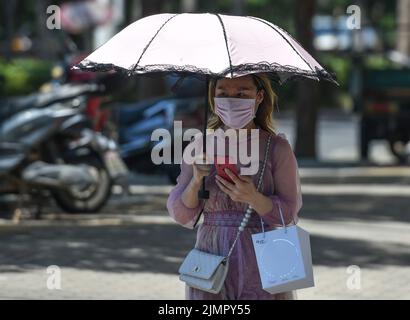 Fuyang, Cina. 07th ago 2022. Una donna cammina lungo la strada tenendo un ombrello durante il tempo caldo. Secondo le previsioni dell'Osservatorio Meteorologico Centrale della Cina, nei prossimi 10 giorni, le alte temperature continueranno in alcune parti della Cina, con la temperatura massima che raggiunge i 37-39 ° C e la temperatura locale di 40 ° C o superiore. (Foto di Sheldon Cooper/SOPA Images/Sipa USA) Credit: Sipa USA/Alamy Live News Foto Stock