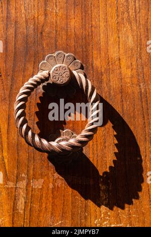 Porta circolare Rusty e ombra su una vecchia porta Weathred Foto Stock