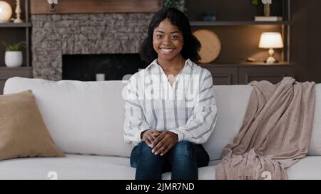 Ragazza africana donna casalinga proprietario di casa donna renter moglie a casa in soggiorno sorridente amichevole guardando la macchina fotografica soddisfatto con l'acquisto di nuova casa rea Foto Stock