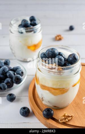 Yogurt con mirtilli freschi e miele è una sana colazione. Foto Stock