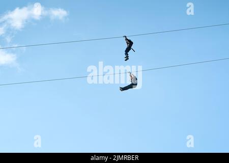 Due coraggiosi uomini avventurosi su una zipline a Magdeburg in Germania Foto Stock