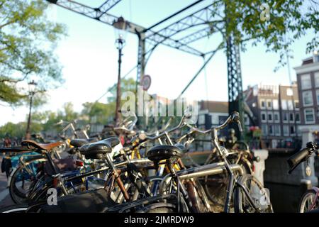 Biciclette di fronte all'iconico ponte di Amsterdam Foto Stock