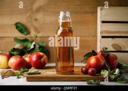 Succo di mela in bottiglia di vetro e frutta fresca con foglie Foto Stock