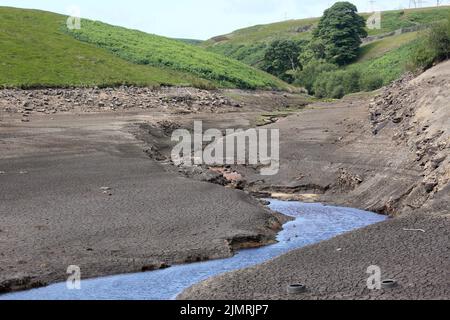 Ripponden, Regno Unito. 7th Agosto 2022. Baitings Reservoir è un grande approvvigionamento idrico gestito da Yorkshire Water and supply's Wakefield. La bassa caduta di pioggia ha lasciato l'acqua bassa con i visitatori in grado di camminare sulle aree di solito piedi sotto l'acqua. Ripponden, Regno Unito. Credit: Barbara Cook/Alamy Live News Foto Stock