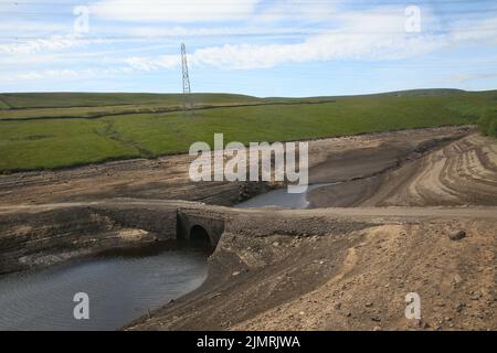 Ripponden, Regno Unito. 7th Agosto 2022. Baitings Reservoir è un grande approvvigionamento idrico gestito da Yorkshire Water and supply's Wakefield. La bassa caduta di pioggia ha lasciato l'acqua bassa con i visitatori in grado di camminare sulle aree di solito piedi sotto l'acqua. Ripponden, Regno Unito. Credit: Barbara Cook/Alamy Live News Foto Stock