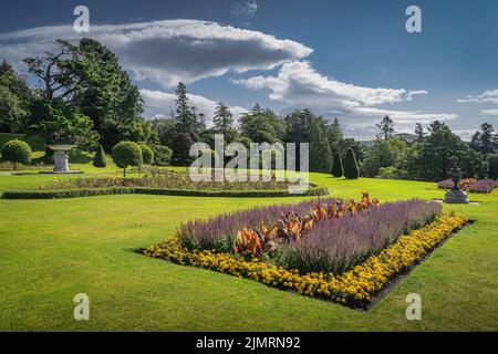 Powerscourt giardino con aiuole, siepi, alberi decorativi, fontane e la foresta sullo sfondo, Irlanda Foto Stock