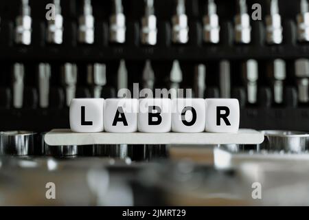 Concetto aziendale. Sullo sfondo di un set di strumenti, cubi bianchi con l'iscrizione - lavoro Foto Stock