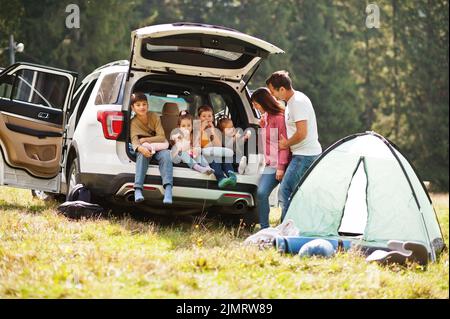 Grande famiglia di quattro bambini. Bambini nel bagagliaio. Viaggiando in auto in montagna, concetto di atmosfera. Lo spirito americano. Foto Stock