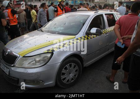 Città di Gaza, striscia di Gaza, Palestina. 7th ago 2022. Gaza, Palestina. 07 agosto 2022. I membri della Difesa civile Palestinese ispezionano un'automobile colpita ad un bivio a Gaza City da aerei da guerra israeliani. Tre palestinesi sono morti a seguito dell'attacco, mentre l'offensiva israeliana continua nella striscia di Gaza per un terzo giorno. Le vittime palestinesi hanno continuato ad aumentare a causa delle continue incursioni aeree israeliane, con almeno 35 palestinesi uccisi e oltre 250 feriti nella striscia di Gaza. La Jihad islamica ha sparato centinaia di razzi in Israele in rappresaglia all'offensiva militare israeliana e al Foto Stock