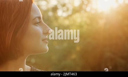 Primo piano bello profilo femmina faccia redhead ragazza donna teen con acconciatura breve trendy attraente sorridente giovane modello fissare capelli posa all'aperto Foto Stock