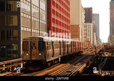 Un treno sopraelevato, o treno L, si dirige in una stazione tra i grattacieli nel Loop of Chicago Foto Stock