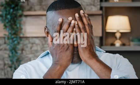 Ritratto maschile Happy Face comic maturo africano americano uomo emotivo bello adulto giocoso pensionato copre testa con palme nasconde il volto facendo grimaces Foto Stock