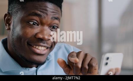 Sorridente felice uomo d'affari africano consigliere brunetto americano ragazzo esperto tenere telefono cellulare guardare display smartphone gadget saluto amico dal video Foto Stock
