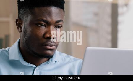 Primo piano african american giovane uomo d'affari freelance web designer lavoro online su personal computer utilizzare wi-fi adulto boss uomo millenario ricerca Foto Stock